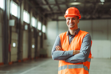 Happy, professional man, foreman, builder wearing hard hat, looking at camera with crossed arms