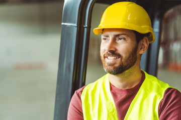 Handsome, bearded man, worker, engineer wearing workwear and hard hat, looking away, copy space