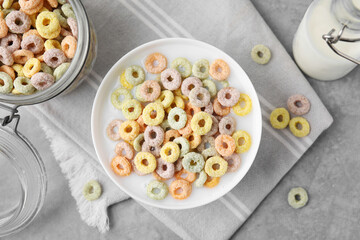 Tasty colorful cereal rings and milk in bowl on grey table, flat lay © New Africa