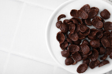 Breakfast cereal. Chocolate corn flakes and milk in bowl on white tiled table, top view. Space for text