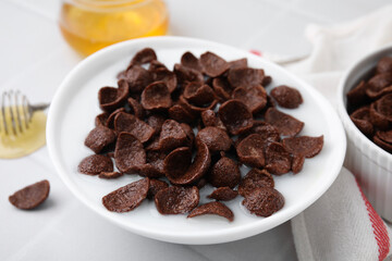 Breakfast cereal. Chocolate corn flakes and milk in bowl on white table, closeup