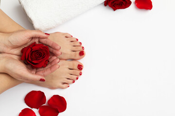 Woman with stylish red toenails after pedicure procedure and rose flowers on white background, top view. Space for text