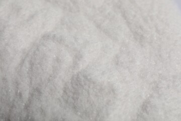 White natural salt as background, closeup view