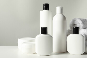 Different bath accessories on white table against grey background, closeup