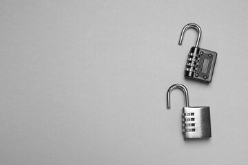 Steel combination padlocks on grey background, top view. Space for text