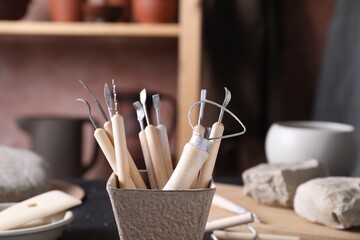 Clay and set of modeling tools on table in workshop, closeup