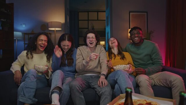 Men and women sharing popcorn while watching comedy show