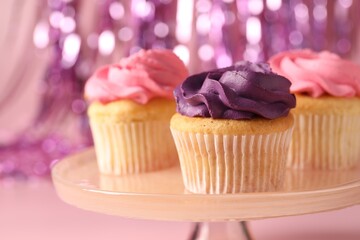 Delicious cupcakes with bright cream on pink background, closeup