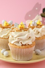 Tasty Easter cupcakes with vanilla cream on pink background, closeup