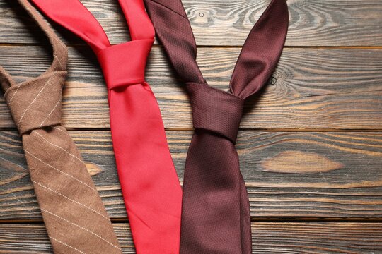 Different neckties on wooden table, flat lay. Space for text