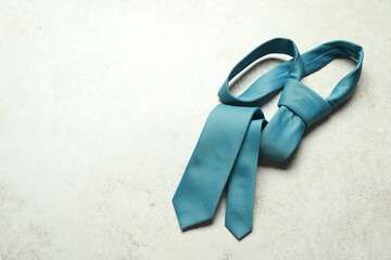 One blue necktie on light textured table, top view. Space for text