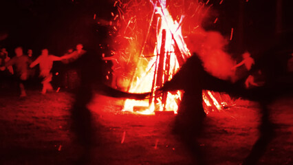 Huge fire at night and young people around. Pagan festival of Walpurgis night: bonfires, dancing...