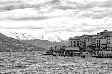Lake Como village Bellagio ferry station background snowy mountains in Italy, Europe in black and white - 786283027