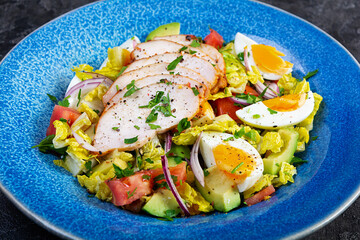 Healthy chicken salad. Fresh salad with avocado, tomato, chicken and herbs