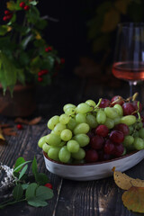 A bowl with red and green grape in rustic style	