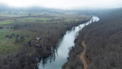 esla river from drone in winter morning next to road and ruined house