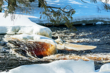 Spring melting of snow on a flowing river under the rays of the sun.