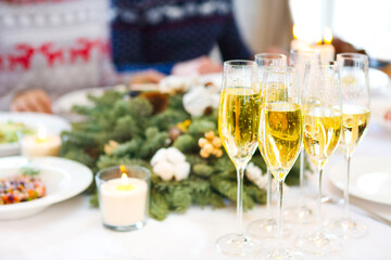 Champagne into a glasses standing on the Christmas table