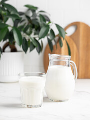 glass and jug of milk in a bright kitchen, dairy products, calcium