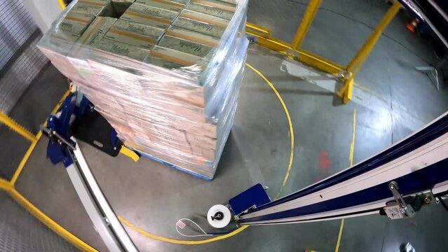 Box stretch wrapping machine. Pallet wrapping machine. Packing boxes in plastic film. Machine for wrapping boxes in a plastic film in a circle.