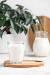 glass and jug of milk in a bright kitchen, dairy products, calcium