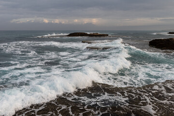 Rough wave and surf action along a rocky section of Mediterranean Sea coast in central Israel.