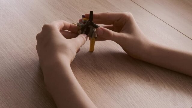 boy created and manipulates with transformer robot, child plays with colored plastic parts constructor, creates equipment, development creativity, fine motor skills