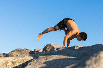Attractive young man practicing yoga meditation outdoors