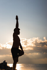 Attractive young man practicing yoga meditation and breath work outdoors