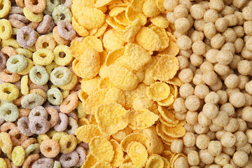 Different types of breakfast cereals as background, top view
