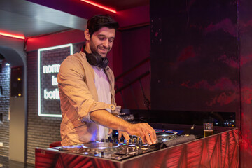 Smiling DJ Mixing Beats at Club Party
