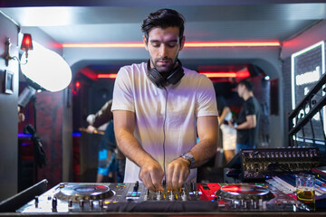 Smiling DJ Mixing Beats at Club Party