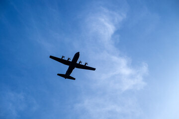 A military airplane silhouette on a blue sky