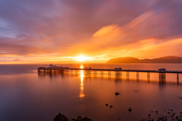 Sunrise over llandudno Pier with the tide in