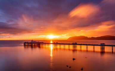 Fototapeta na wymiar Sunrise over llandudno Pier with the tide in