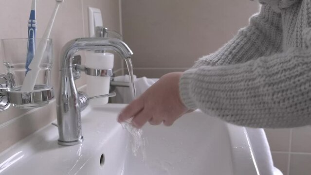 mature woman diligently brushes teeth and rinses her mouth with water over bathroom sink after eating, dental cleanliness, Maintaining good oral health through regular brushing