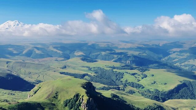 View of Elbrus from the Bermamyt plateau. Caucasus 2023. A trip to Bermamyt, the Grand Canyon in Russia. Mountain landscape on a summer day. Blue sky of Karachay-Cherkessia. Caucasian Ridge 4K