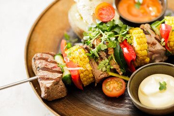 Dutch skewers with corn and cow steak, vegetables and sauce