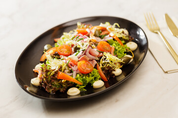 Fresh  Vegetable green salad with sauce on a black plate