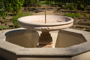 antique fountain in the Italian green botanical garden in summer on a hot day