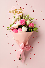 Bouquet of flowers and confetti on pink background. Happy Mothers Day concept.