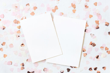 Cards between pink hearts on white table top view, valentines mockup