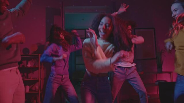Latino young female dancing around multiethnic friends