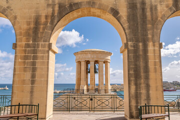 The Siege Bell War Memorial framed by an arch of the Lower Barrakka Gardens, Valletta, Malta