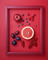 Red fruits and berries in wooden picture frame