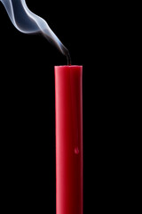 Pink wax candle with smoke on black background