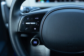 Close-up view of car interior. View of steering wheel of car control music. Volume button of car...