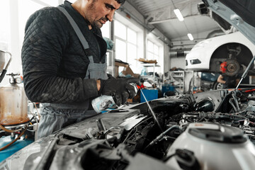 Mechanic examining car in auto car repair service center