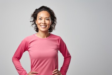 Portrait of a tender asian woman in her 30s wearing a moisture-wicking running shirt isolated on white background