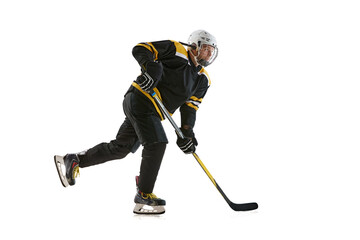 Young man wearing black and yellow uniform, hockey player in motion with stick during game isolated on white background. Concept of professional sport, competition, game, tournament